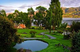 Peaceful landscape with pond, trees, and red-roofed house in Peru | Ile Tours