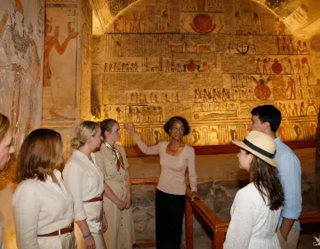 Elite Egyptologist providing private intellectual curation to an exclusive group inside a vibrantly preserved tomb in the Valley of the Kings | Ile Tours