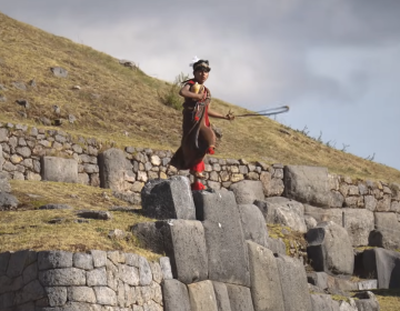 Inti Raymi performer in traditional costume on stone terraces of Sacsayhuamán archaeological site in Cusco | Ile Tours