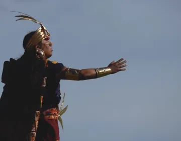 Inti Raymi performer in elaborate Inca ceremonial attire with golden ornaments and feathered headdress | Ile Tours