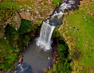Peruvian Andean waterfall with rocky terrain and green vegetation | Ile Tours