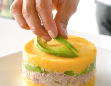 Peruvian causa limeña dish with potato layers and colorful toppings | Ile Tours