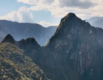 Machu Picchu ruins with terraces and mist-covered Huayna Picchu from restricted circuits | Ile Tours