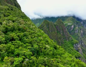 Machu Picchu ruins with terraces and mist-covered mountains | Ile Tours