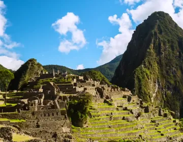 Machu Picchu ruins with terraces and mist-covered mountains | Ile Tours