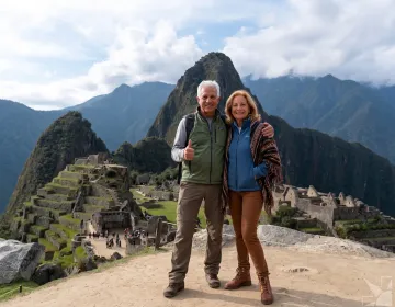 Senior travelers at Machu Picchu viewpoint with iconic ruins and mountains | Ile Tours