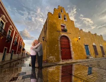 Senior travelers in colorful colonial street surrounded by historic architecture in Mexico | Ile Tours