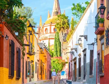 Colonial street in San Miguel de Allende with vibrant architecture and Parroquia de San Miguel Arcángel | Ile Tours