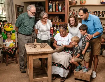 Multi-generational family observing traditional pottery demonstration inside private artisan workshop in Mexico | Ile Tours