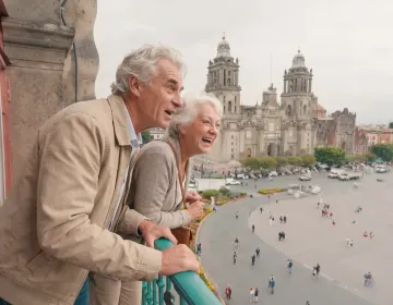 Senior couple overlooking Mexico City historic center and cathedral from elevated viewpoint during mild weather conditions | Ile Tours