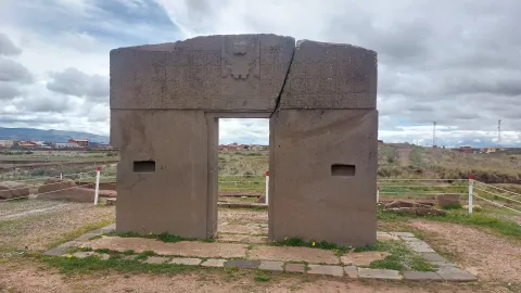 Discover the Mysteries of Ancient Civilizations with Ile Tours Ancient stone monument with engraved inscriptions, standing in an open landscape under a cloudy sky | Ile Tours