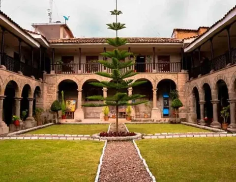 Interior courtyard of a colonial mansion in Ayacucho with stone arches and a central tree | Ile Tours