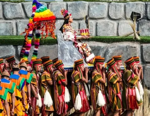 A rainha inca (Qoya) sendo carregada em um trono durante uma procissão no festival Inti Raymi.