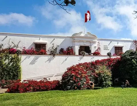 Fachada exterior del Museo Larco en Lima adornada con flores coloridas | Ile Tours