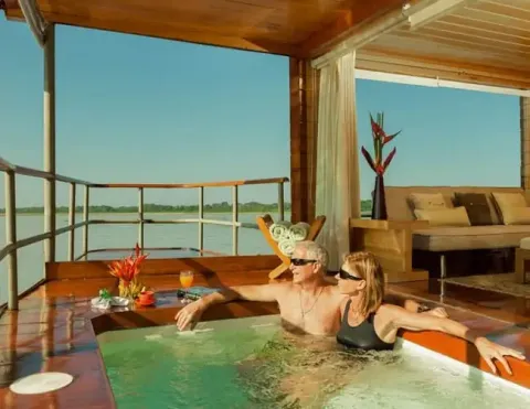 Um casal desfrutando de um momento relaxante em uma banheira de hidromassagem em um barco de luxo, com vista para o rio | Ile Tours