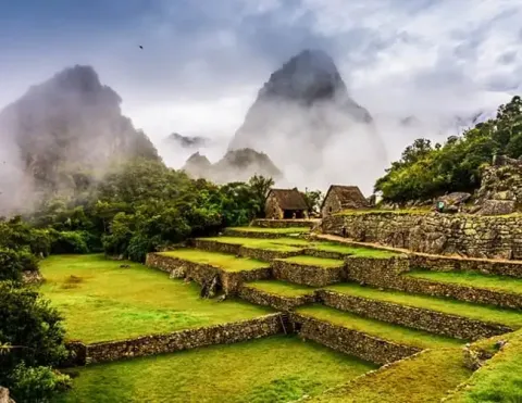 Antiguas ruinas de piedra en Machu Picchu rodeadas de montañas brumosas | Ile Tours