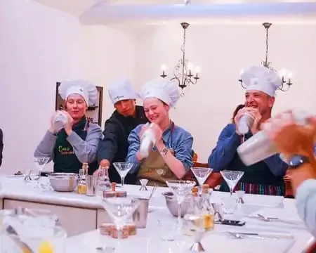 A chef and a tourist exploring a vibrant local market in Peru as part of a cooking class, selecting fresh produce for their meal | Ile Tours