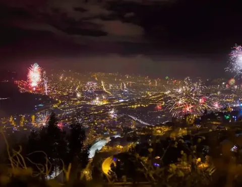 Vista panorámica nocturna de la ciudad de Cusco con fuegos artificiales en Año Nuevo | Ile Tours