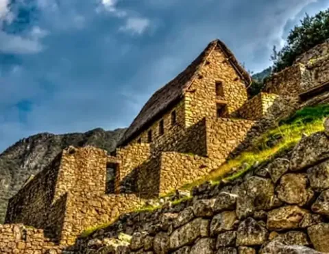 Vista panorâmica da magnífica Machu Picchu, exibindo a antiga cidadela inca, a icônica montanha Huayna Picchu e os exuberantes terraços agrícolas verdes sob um céu azul claro | Ile Tours