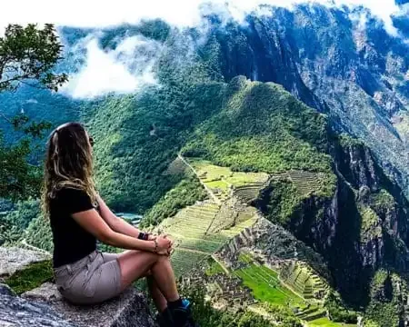 Una viajera admirando la impresionante vista de Machu Picchu desde arriba | Ile Tours