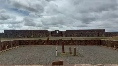 The ancient ruins of Tiwanaku, featuring stone structures and monoliths under a cloudy sky, highlighting the significance of this pre-Columbian archaeological site in Bolivia | Ile Tours