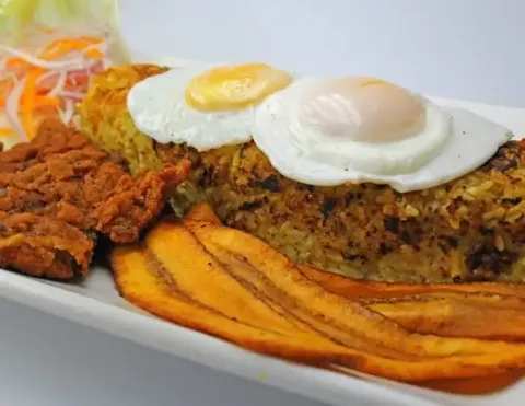 A hearty plate of Peruvian Tacu Tacu, a seasoned rice and bean pancake, topped with a juicy steak and a perfectly fried egg | Ile Tours